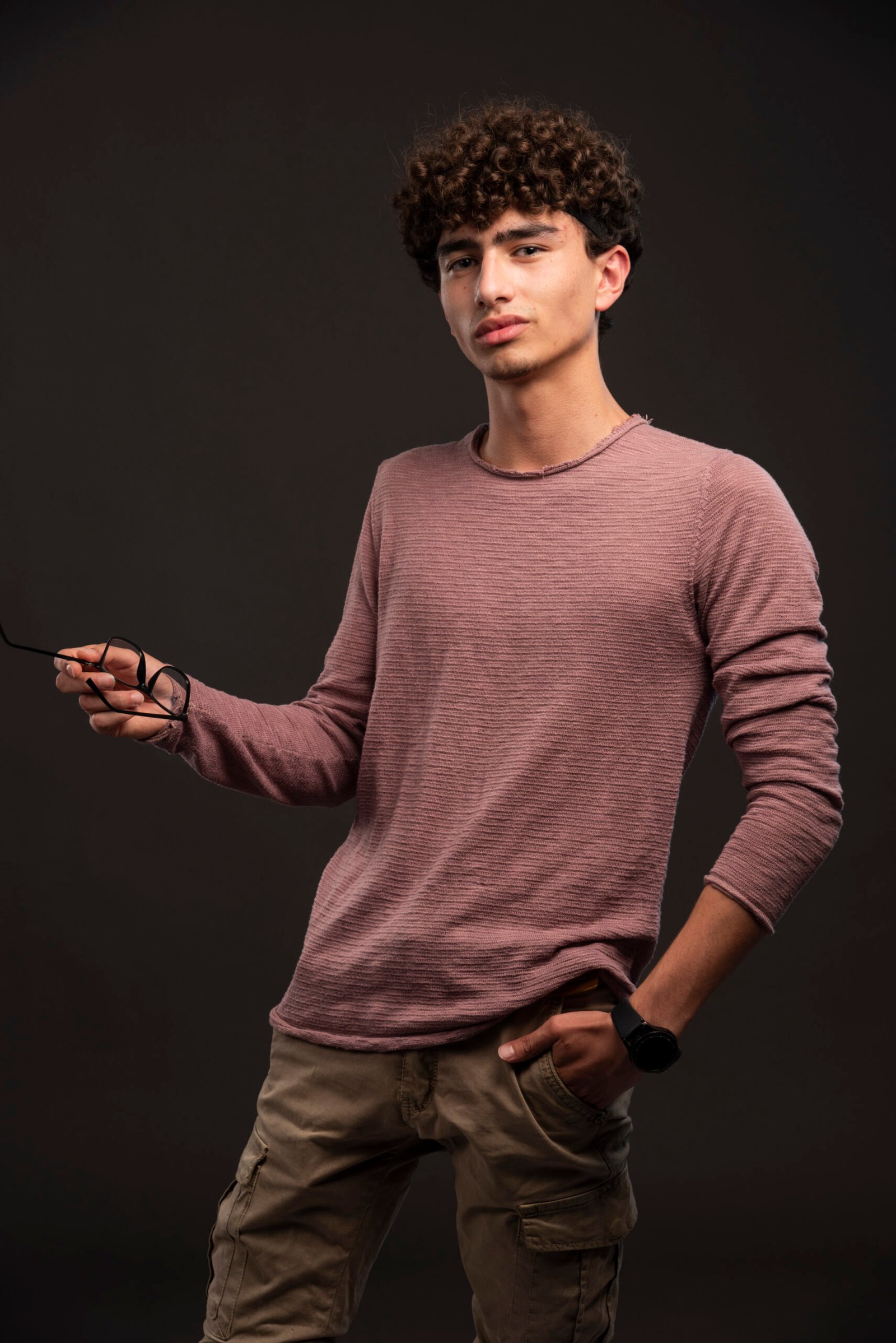 Young model in casual fall winter outfits holding eyeglasses. High quality photo